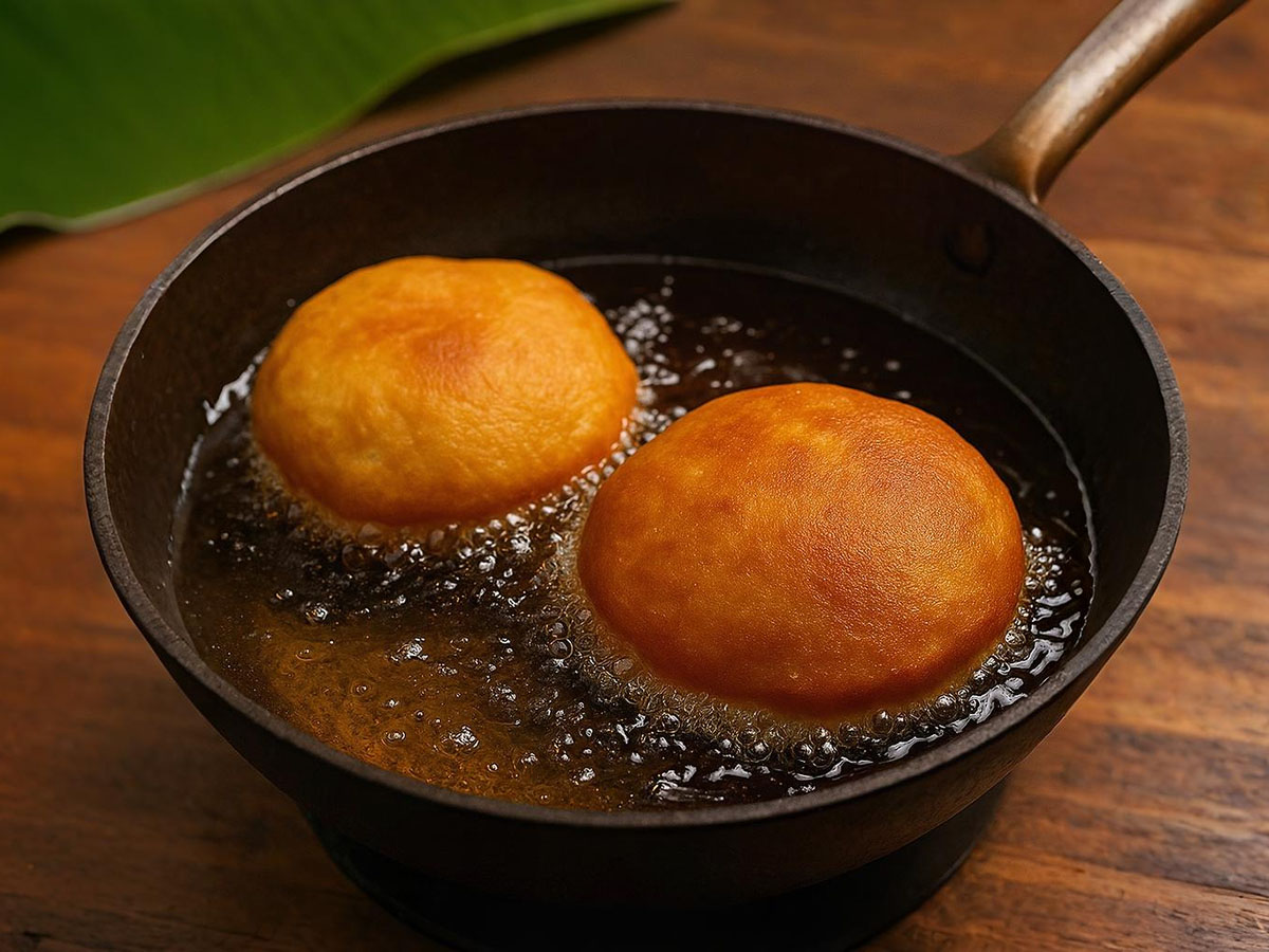 Frying Mangalore buns in hot oil until golden and puffed